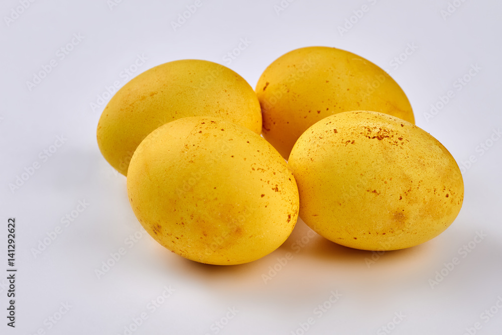 Yellow dyed eggs isolated. Four eggs on white background.