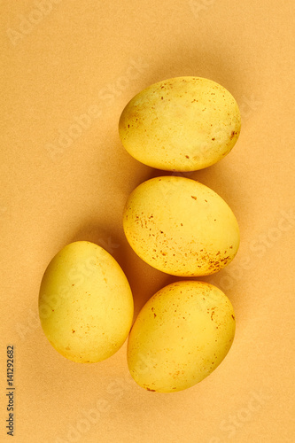 Dyed eggs on yellow background. Four chicken eggs.