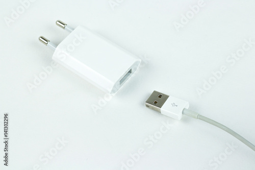 Closeup of a white charger and white usb cable. Isolated on a white background.