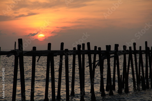 Sunset over the sea and wood bridge 