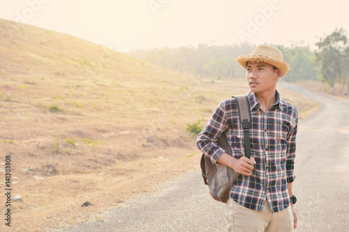 Happy Asian hipster man backpack in nature background  Relax time on holiday concept travel   color of vintage tone and soft focus