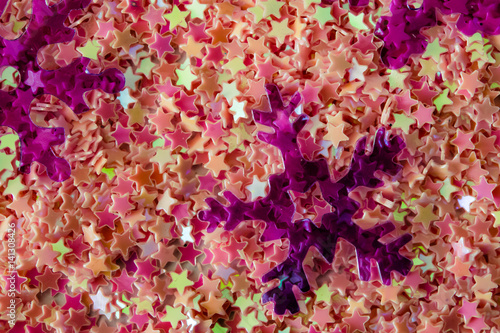 Abstract background of brightly colored plastic stars and snowflakes © golubka57