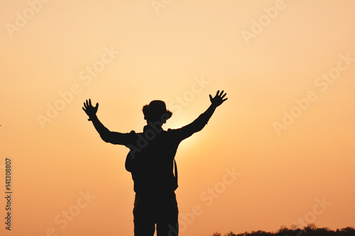 Silhouette of happy Asian hipster man backpack in nature background, Relax time on holiday concept travel , color of vintage tone and soft focus