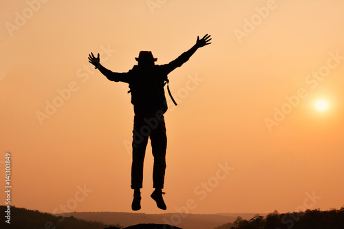 Silhouette of happy Asian hipster man backpack in nature background, Relax time on holiday concept travel , color of vintage tone and soft focus