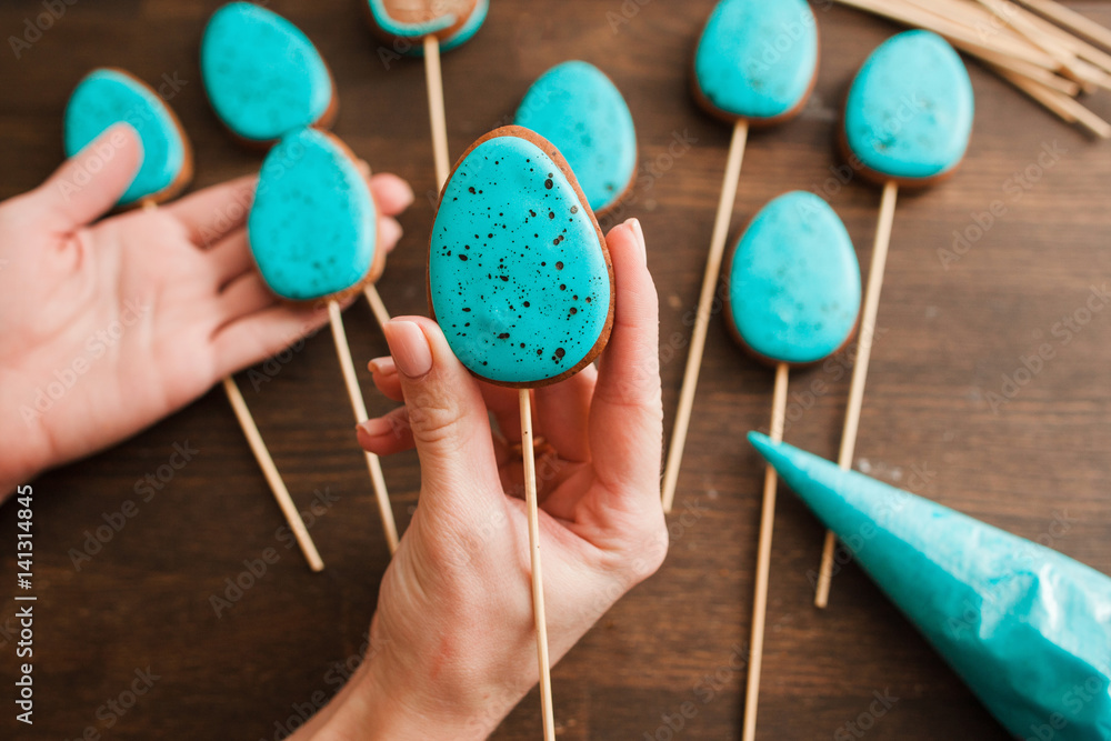 Preparing easter cookies with blue icing for decoration on rustic wooden table top view Preparing easter cookies with blue icing for decoration on rustic wooden table top view