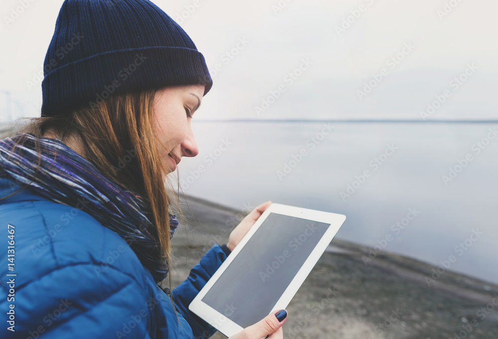 Smiling young woman holding tablet standing on the city waterfront Smiling young woman holding tablet standing on the city waterfront