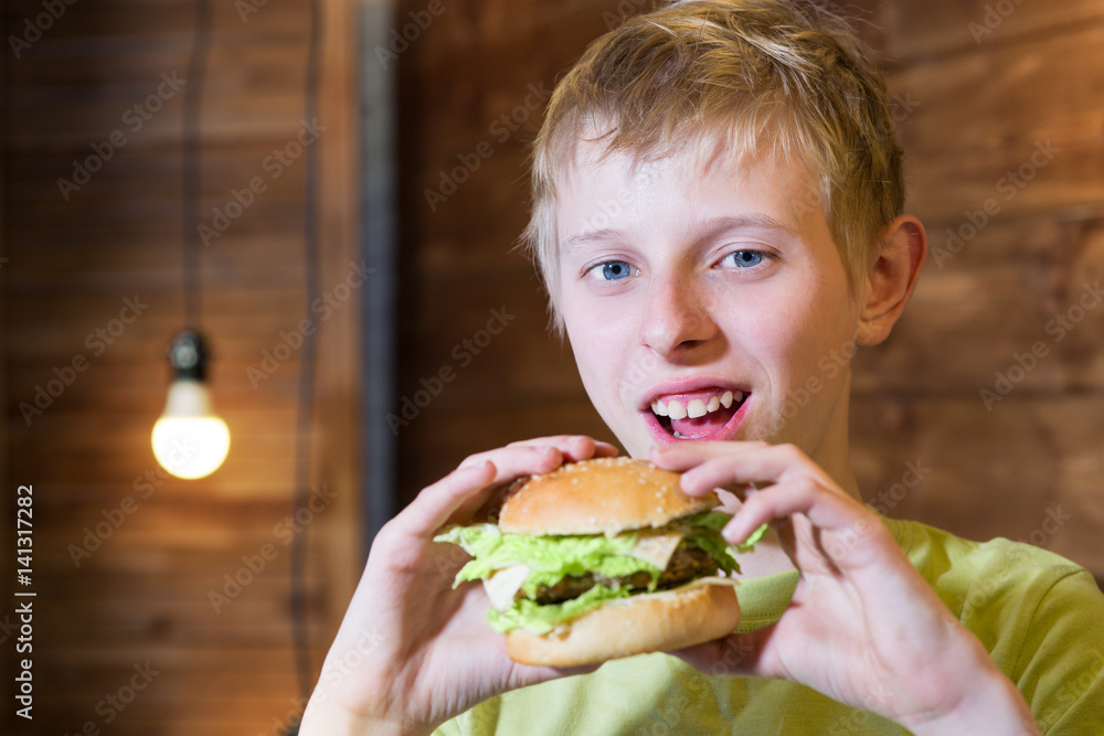 A teenager eating a sandwich