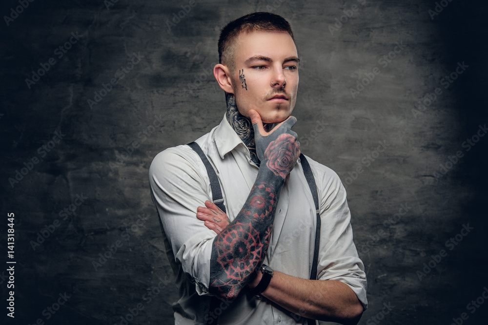 A man with a tattoo on his face and arms.