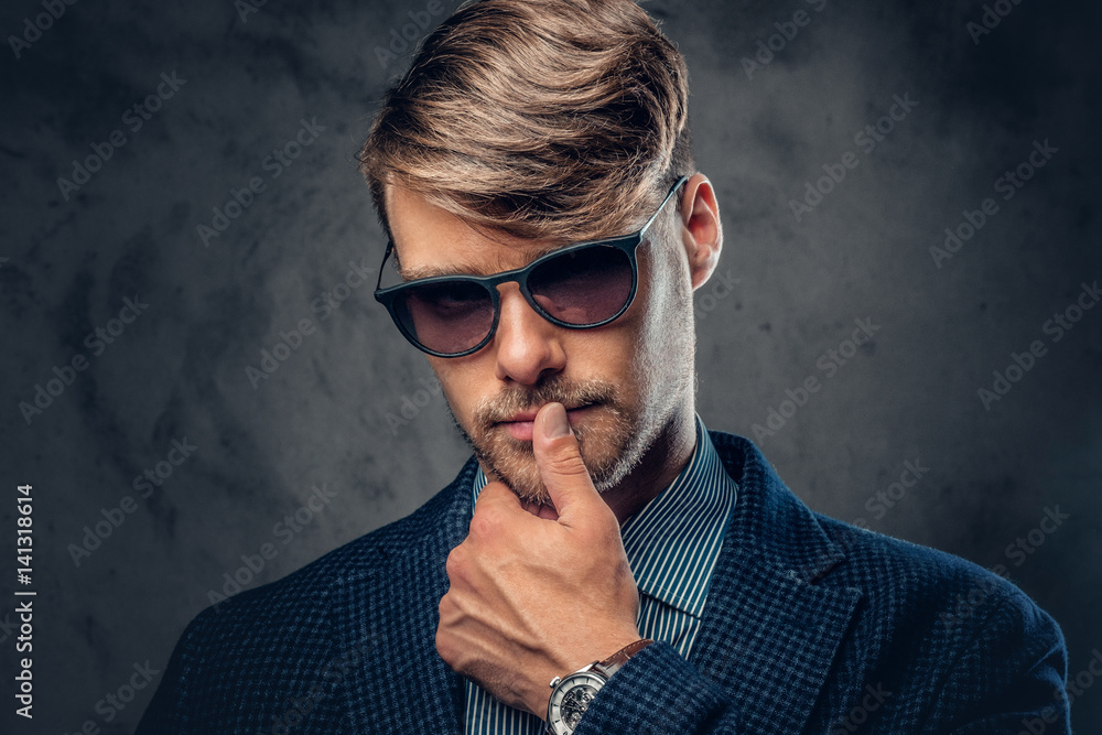 Portrait of stylish male in sunglasses over grey background. Portrait of stylish male in sunglasses over grey background.