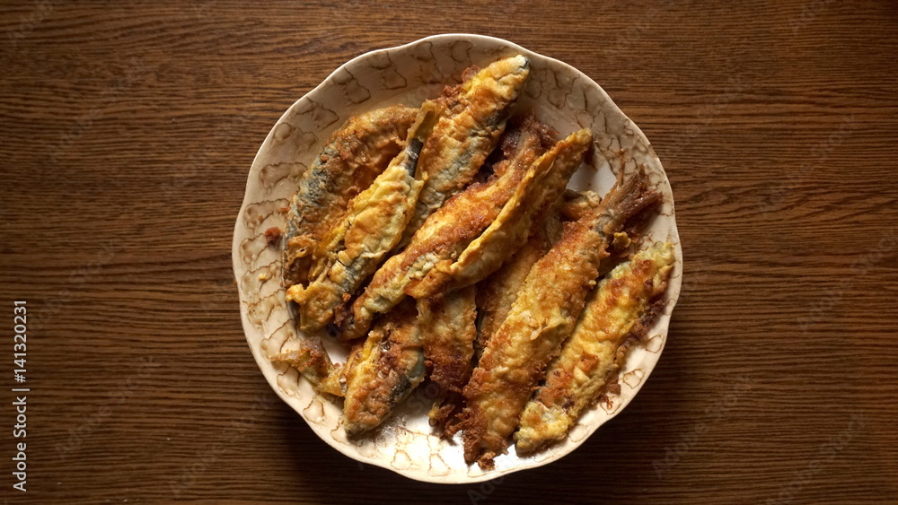 Fried fish in the plate on the table Fried fish in the plate on the table