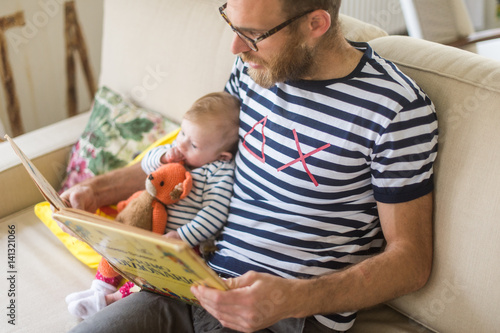 Giovane ragazzo legge libro alla figlia photo