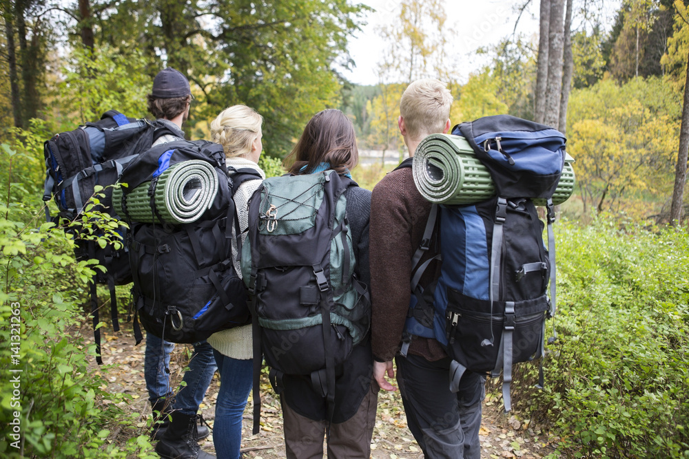 Friends With Backpacks And Rolled Mats In Forest Friends With Backpacks And Rolled Mats In Forest