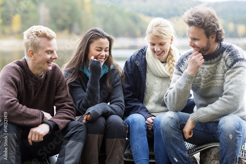 Smiling Friends Enjoying Camping On Lakeshore