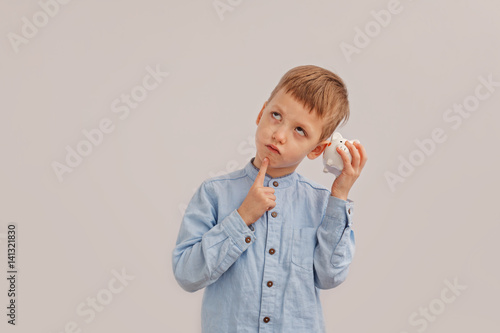 Cute little boy holding a piggy bank or money box. Concept child and money