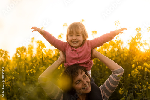 Little girl enjoying ride on her mothers shoulder