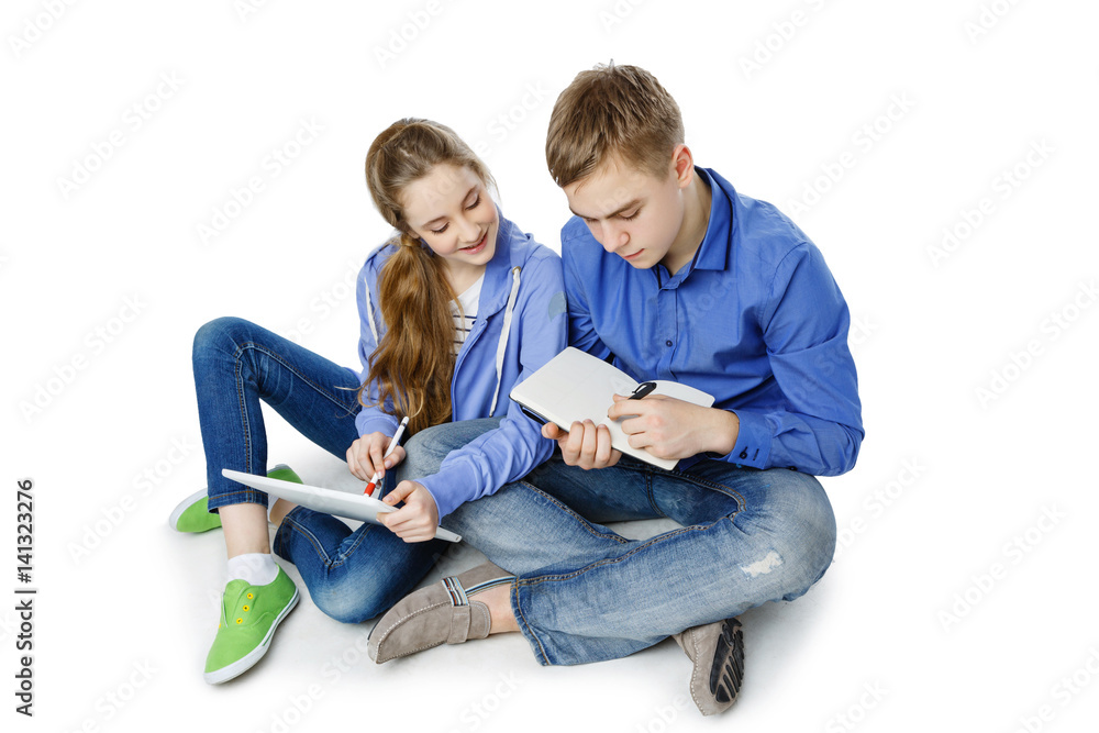 Teen age boy and girl with tablet and notebook Teen age boy and girl with tablet and notebook