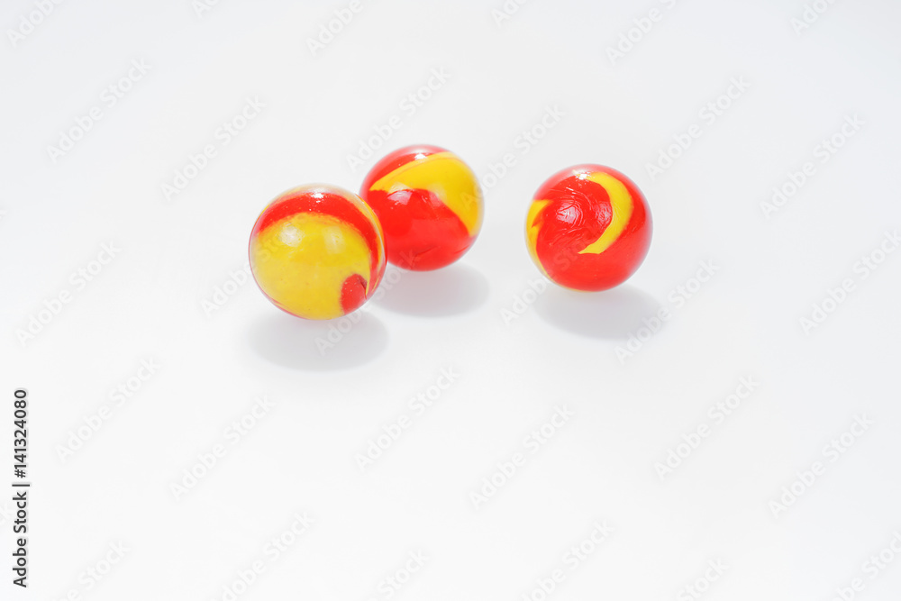 Three red yellow marbles isolated on white background