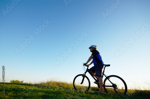 Adult cyclist silhouette having rest dusk time