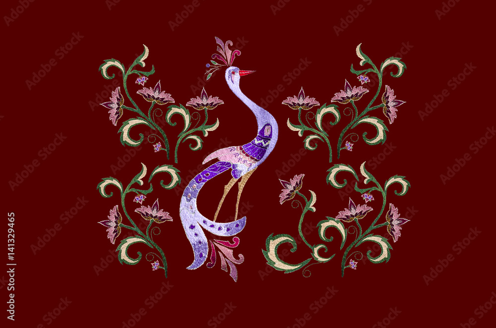 Vinous background with embroidered stylized bird among branch with flowers and twisted leaves Vinous background with embroidered stylized bird among branch with flowers and twisted leaves
