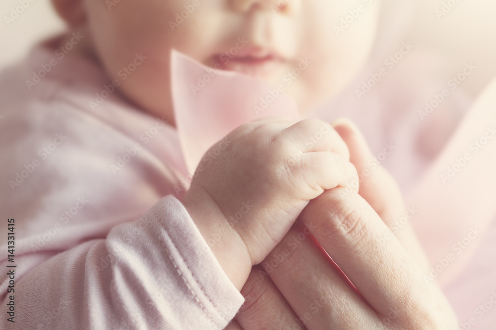 Little Cute Baby Hands in Mother Hand. Pink Background. Little Cute Baby Hands in Mother Hand. Pink Background.