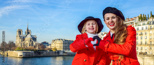 stylish mother and daughter in Paris showing heart shaped hands photo