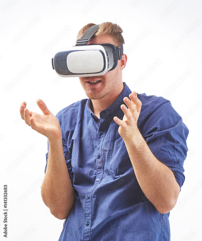 Excited young man using a VR headset enjoying interactive game with emotion and experiencing virtual reality isolated on white background studio shot Excited young man using a VR headset enjoying interactive game with emotion and experiencing virtual reality isolated on white background studio shot