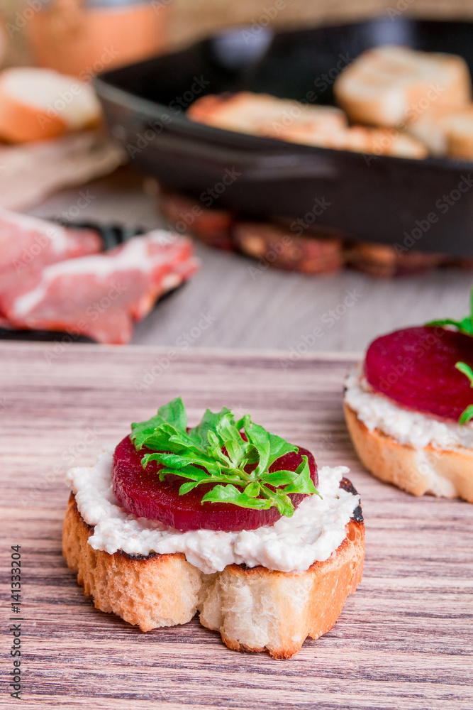 Bruschetta with creame cheese and beet on wooden background.