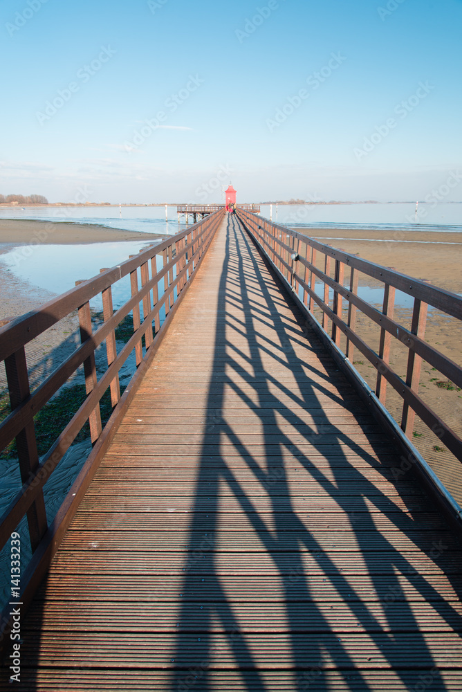 Fototapeta premium The old red lighthouse in Lignano Sabbiadoro