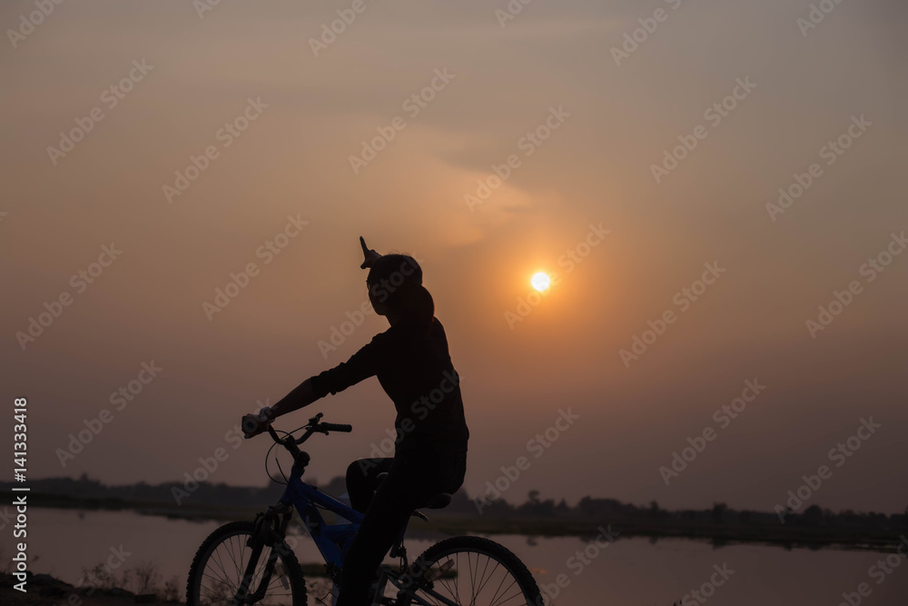 Fototapeta premium Woman biking hands at sunset. 