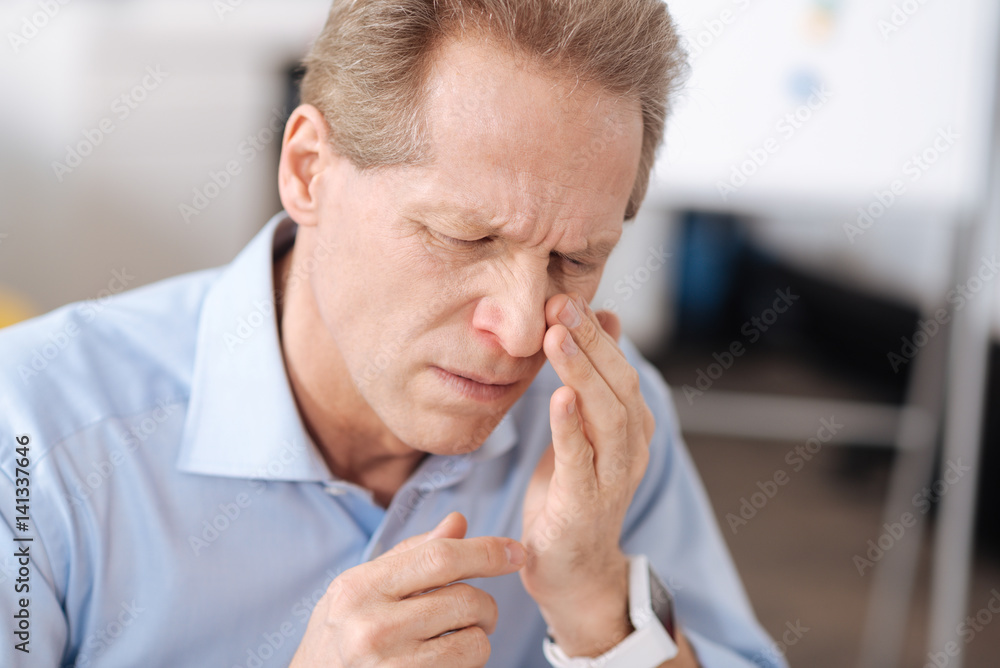 Disheveled man looking at his nose Disheveled man looking at his nose