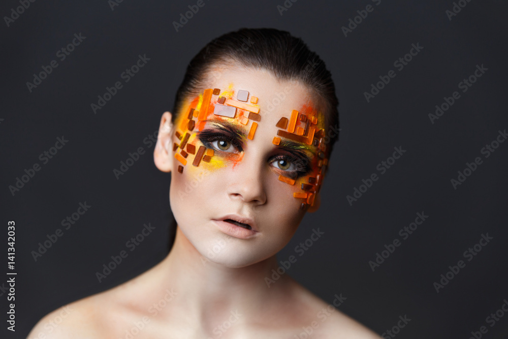 Girl with orange and red rhinestones on her face. Girl with orange and red rhinestones on her face.