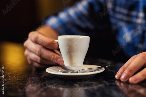 handsome young man drinking coffee while sitting at bar counter.enjoying coffee Cafe Coffee Caffeine Casual Relaxation Style Concept.Young fashion man   hipster drinking espresso coffee in city cafe