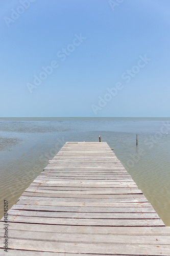 Old wooden bridge to the sea, tranquil scene for traveling and relaxation.