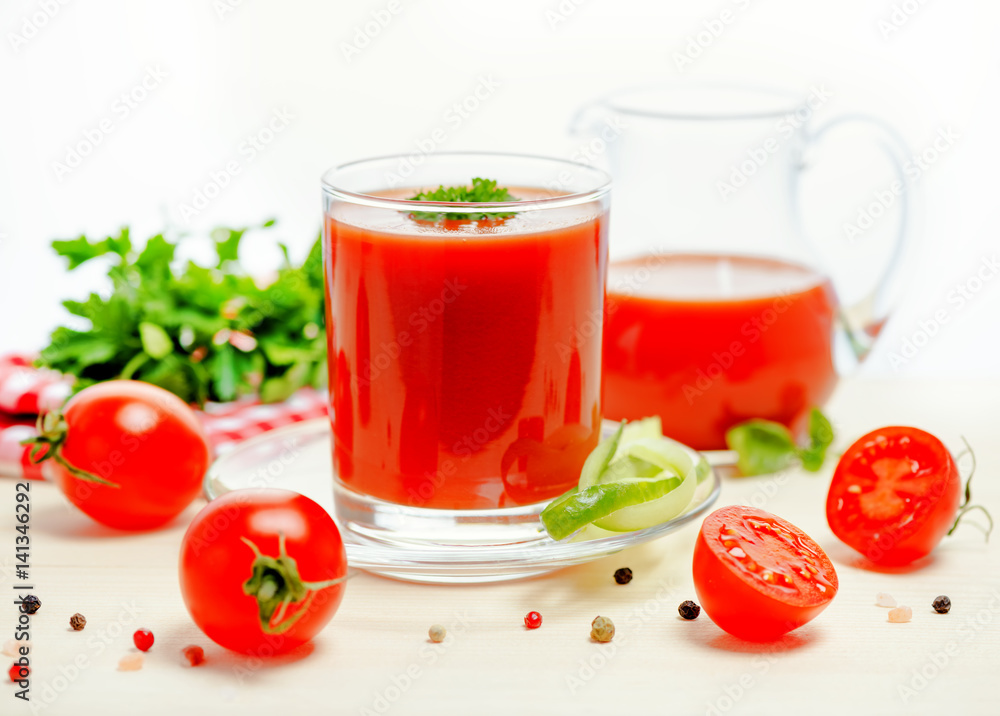 tomato juice in glass, jug with greenery, basil, cutted tomato fruit and dry pepper on light table, concept vegetarian food, close up tomato juice in glass, jug with greenery, basil, cutted tomato fruit and dry pepper on light table, concept vegetarian food, close up