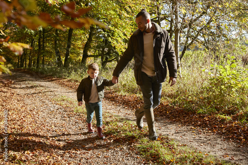 Father And Son On Autumn Walk In Woodland Together
