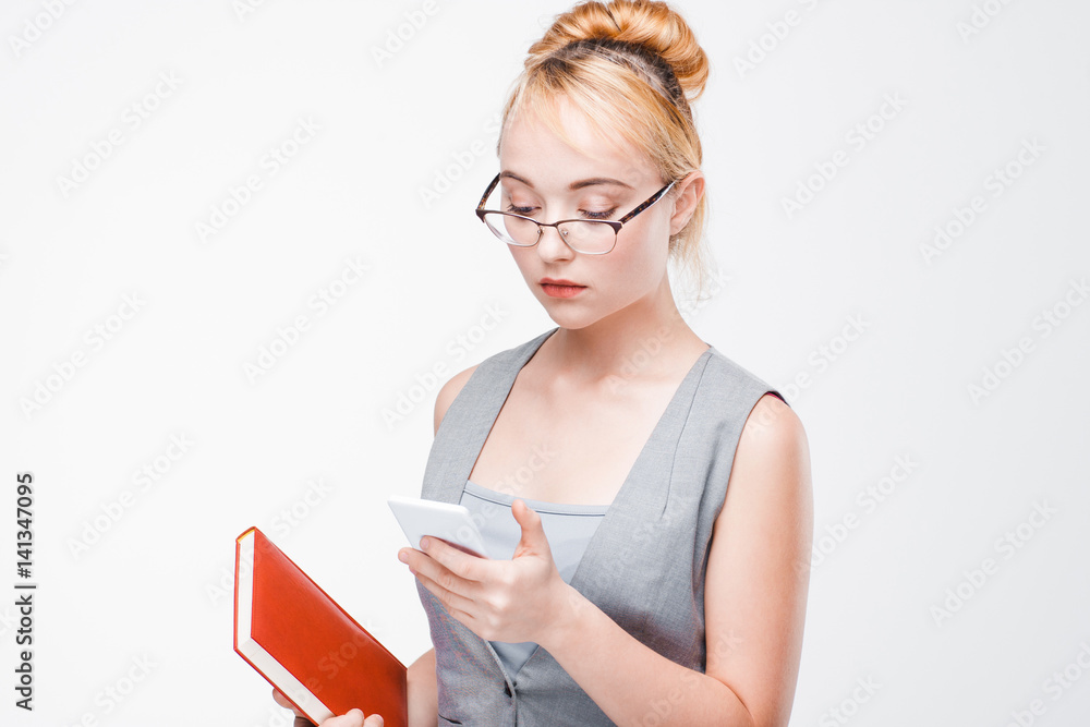 Young nice blonde in glasses and vest addicted to smartphone. Pathological dependence on the mobile phone, nomophobia. Young nice blonde in glasses and vest addicted to smartphone. Pathological dependence on the mobile phone, nomophobia.