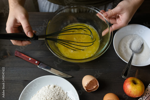 Hands mixing eggs in bowl photo