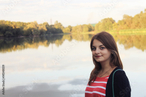 beautiful young woman walking near lake © pavelkant