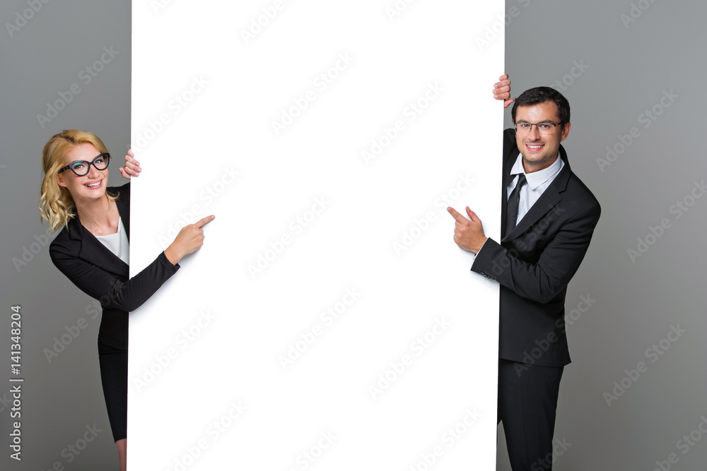 Businessman and business woman with big empty poster Businessman and business woman with big empty poster