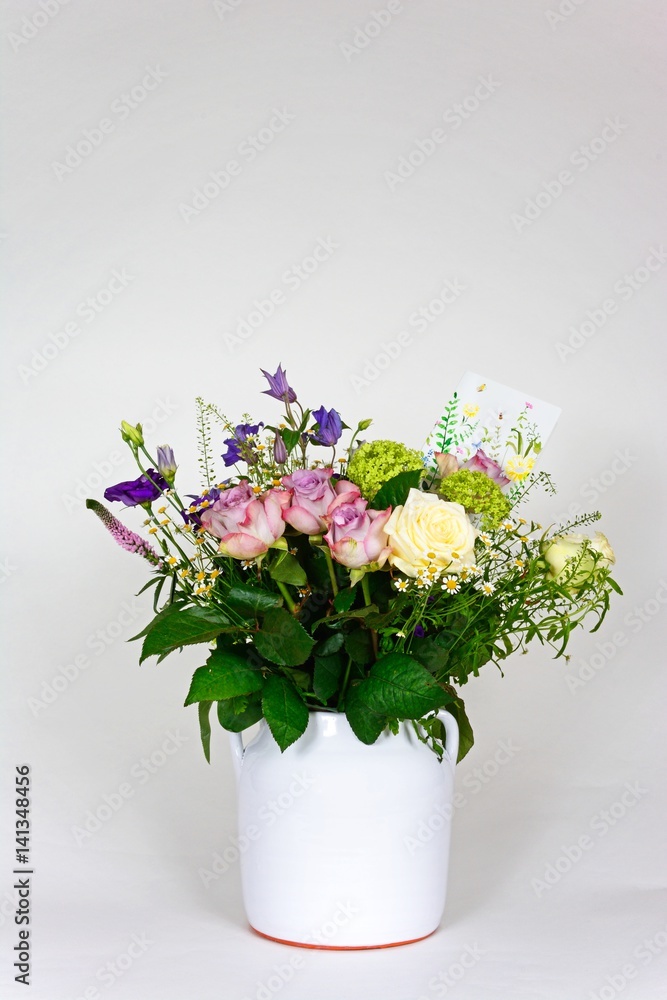 Bouquet of flowers in a white vase against a white background. Bouquet of flowers in a white vase against a white background.