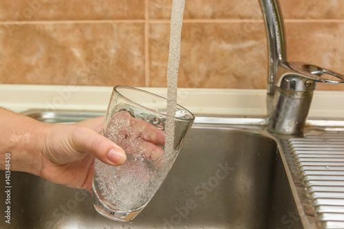 Hand holding glass of water
