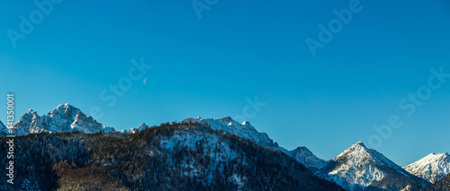 View of the German Alps in winter against a blue sky