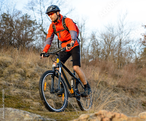 Enduro Cyclist Riding the Mountain Bike on the Rocky Trail. Extreme Sport Concept. Space for Text.