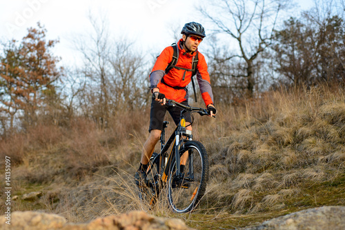 Enduro Cyclist Riding the Mountain Bike on the Rocky Trail. Extreme Sport Concept. Space for Text.