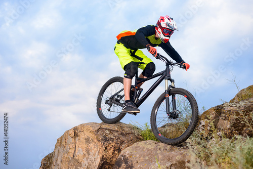 Professional Cyclist Riding the Bike on the Top of the Rock. Extreme Sport Concept. Space for Text.