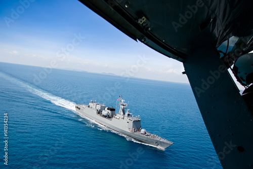 Grey modern warship, helicopter view