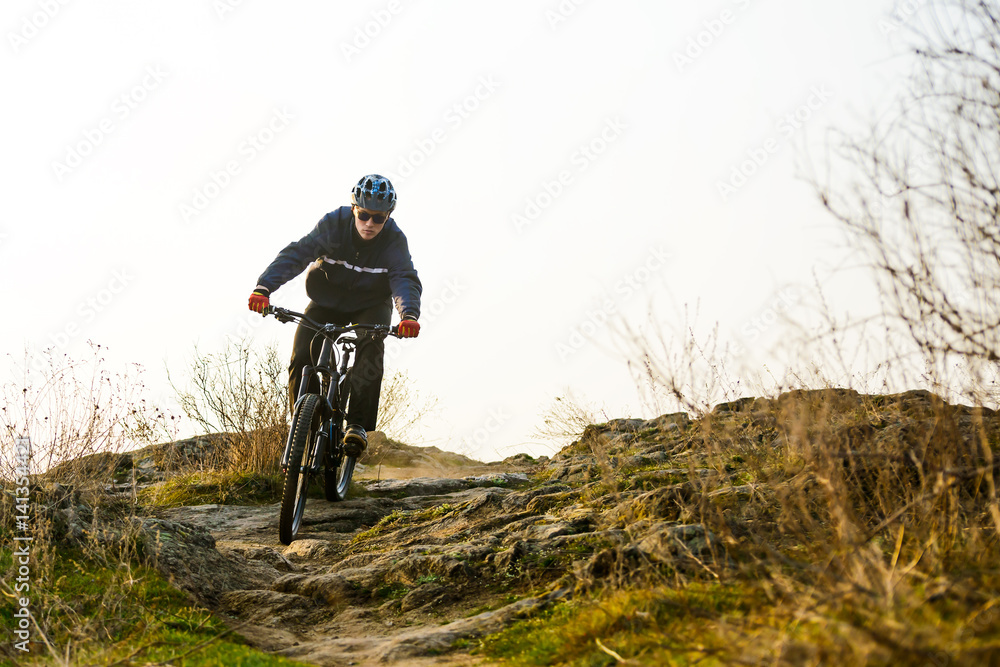 Enduro Cyclist Riding the Mountain Bike Down Beautiful Rocky Trail. Extreme Sport Concept. Space for Text. Enduro Cyclist Riding the Mountain Bike Down Beautiful Rocky Trail. Extreme Sport Concept. Space for Text.