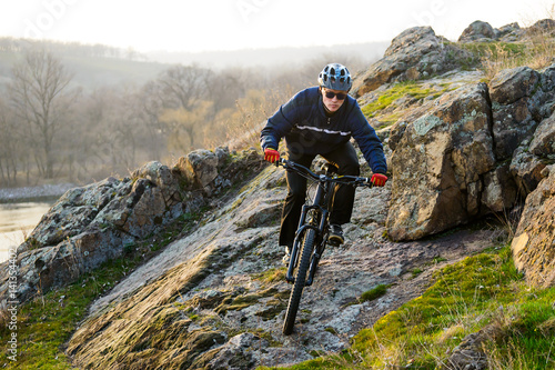 Enduro Cyclist Riding the Mountain Bike Down Beautiful Rocky Trail. Extreme Sport Concept. Space for Text.