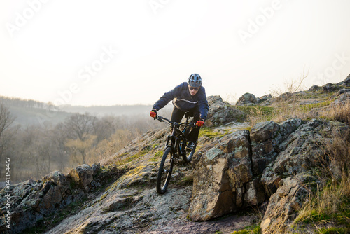 Enduro Cyclist Riding the Mountain Bike Down Beautiful Rocky Trail. Extreme Sport Concept. Space for Text.