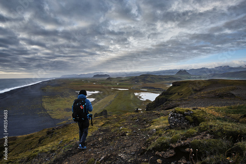 A man walking on top of Dyrholaey, Iceland